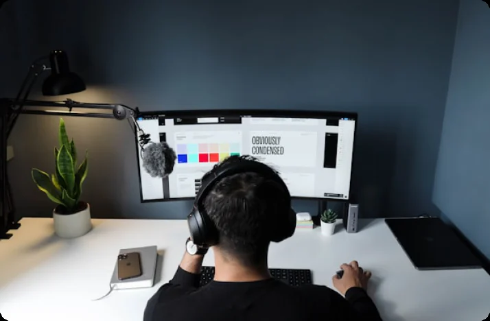 Designer at a screen showing brand colours and type