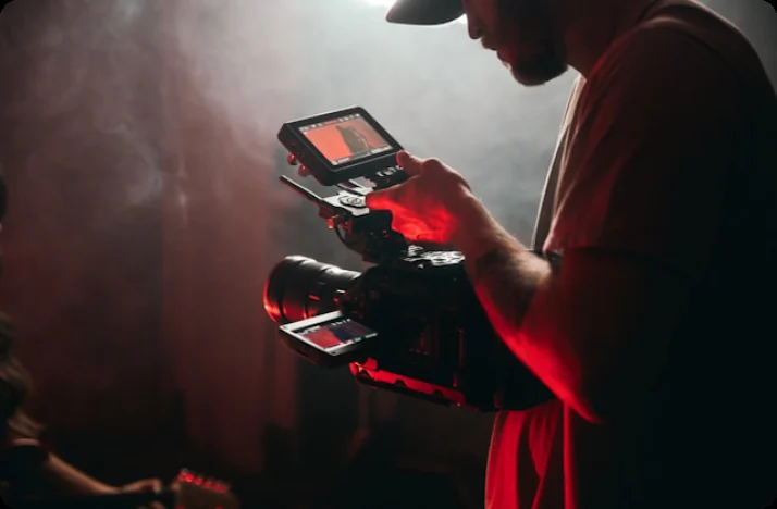 Camera operator checking a shot on a monitor in red light